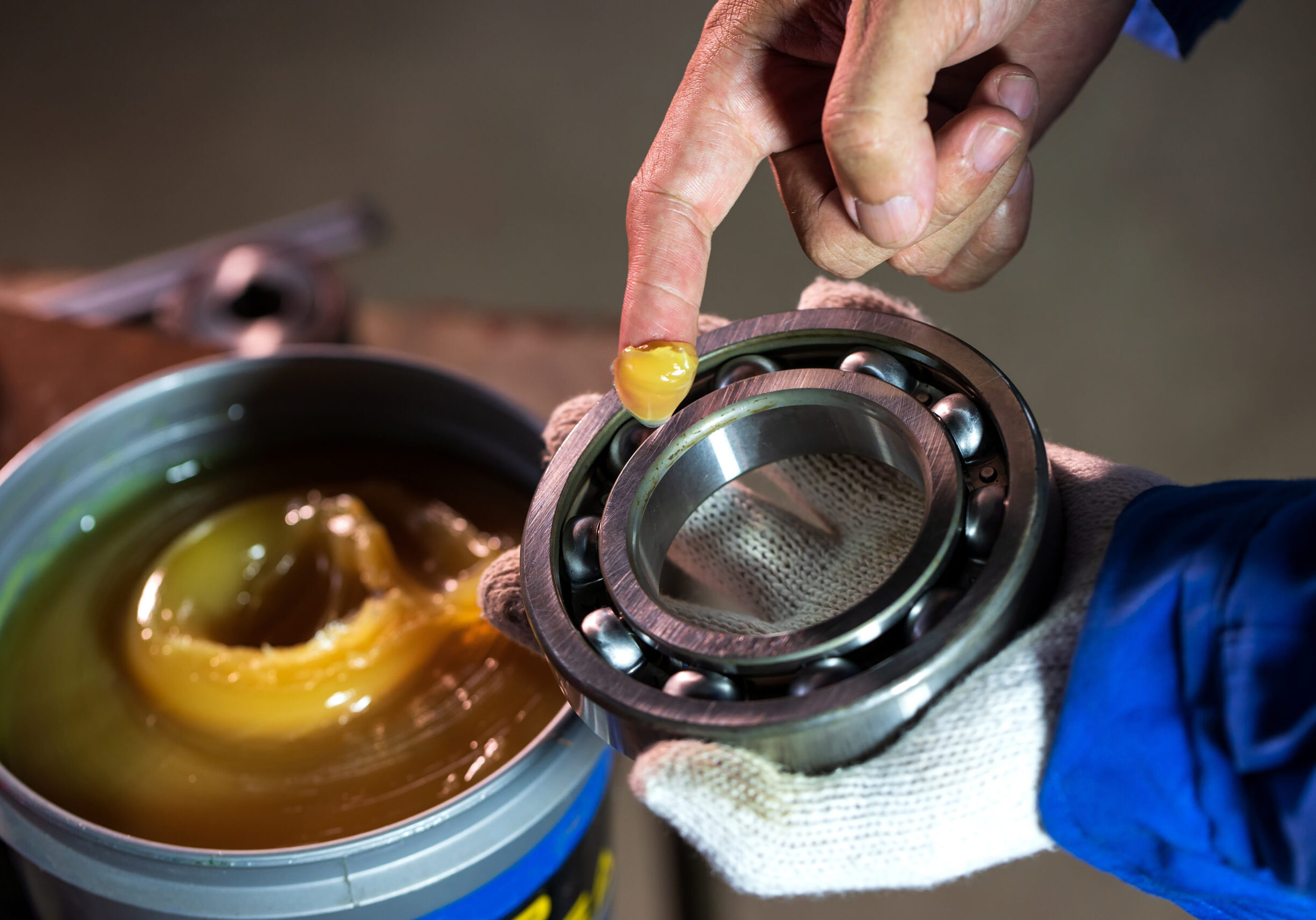 Close up of lubricant grease in hand Mechanic for putting into ball bearing in the industrial factory, Mechanic Industrial Concept